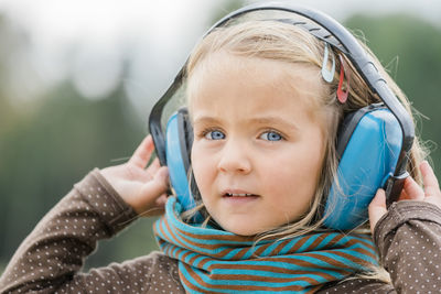 Close-up portrait of girl wearing ear protector