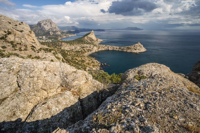 Rock formations by sea against sky