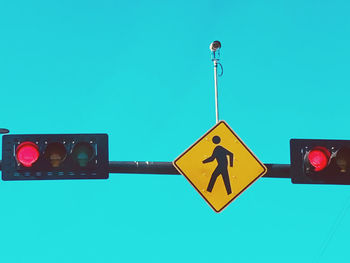 Low angle view of road sign against clear blue sky