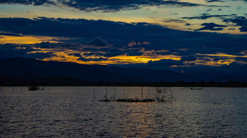 Scenic view of lake against sky at sunset