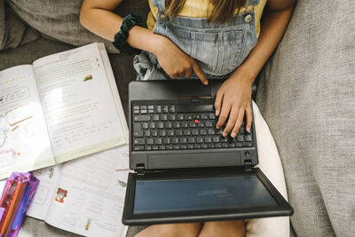 Girl learning online through laptop at home