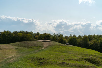 Scenic view of trees on field with observation cuppola against sky