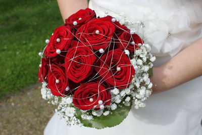 Close-up of hand holding red bouquet