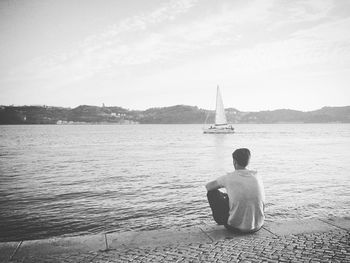 Rear view of man sitting on boat