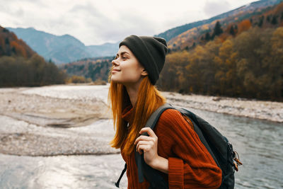 Young woman looking away while standing on mountain