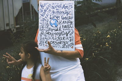 Rear view of two women standing in front of text