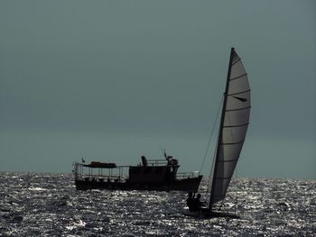 Sailboat sailing on sea against clear sky