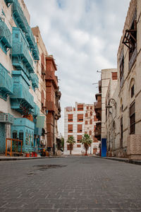 Street amidst buildings in town against sky