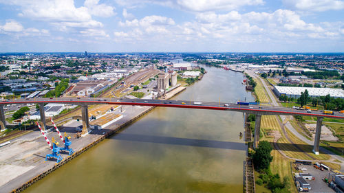 Aerial view of cityscape by sea against sky