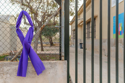 Clothes hanging on metal fence against building