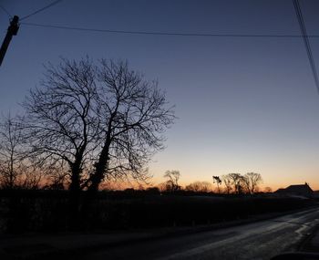 Silhouette bare tree against clear sky at sunset