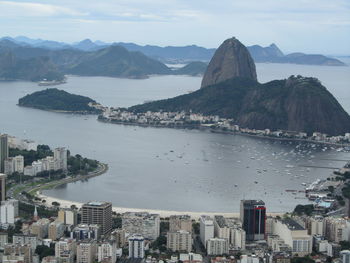 High angle view of city by sea against sky