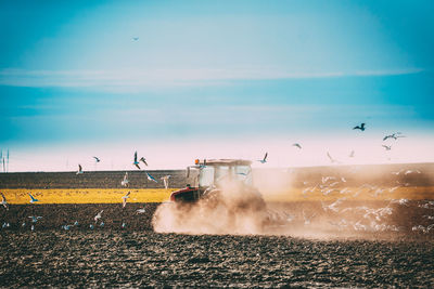 Tractor on agricultural land against sky