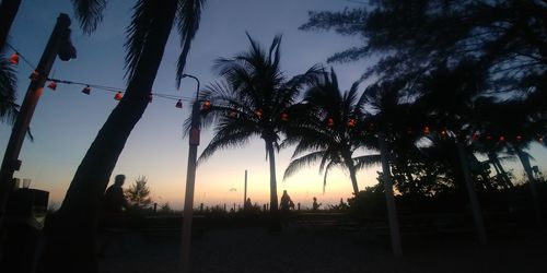 Silhouette palm trees against sky during sunset