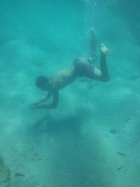 Full length of shirtless boy swimming in sea