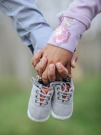 Cropped hands of couple holding baby booties