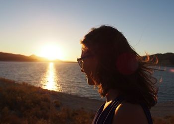 Rear view of woman looking at sunset