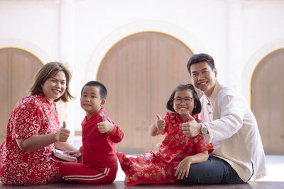 Portrait of cheerful family gesturing while sitting outdoors