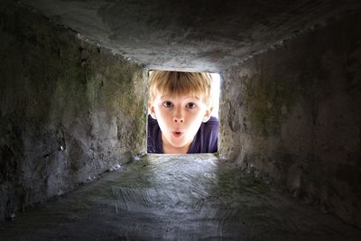 Portrait of boy seen through concrete