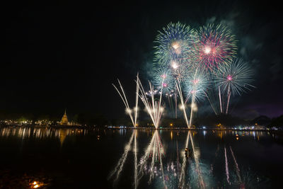 Firework display over river at night