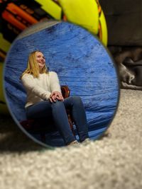 Full length of a smiling woman sitting outdoors