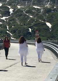 Rear view of women walking on mountain road