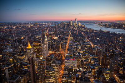 Aerial view of city lit up at sunset