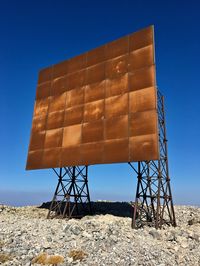 Low angle view of billboard against clear blue sky