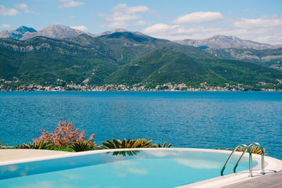 Scenic view of lake by mountains against sky