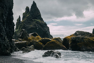 Rock formations by sea against sky