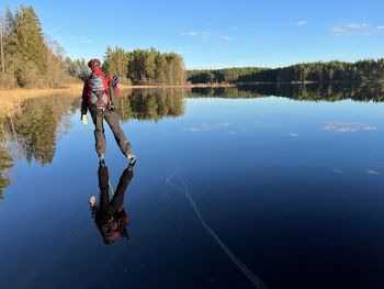 Rear view of woman standing by lake
