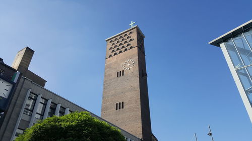 Low angle view of clock tower against blue sky