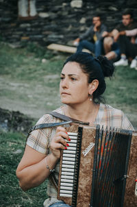 Young woman looking away while standing outdoors