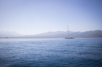 Sailboat in sea against blue sky