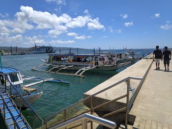 People on boat in sea against sky