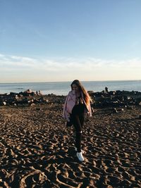 Full length of woman on beach against sky