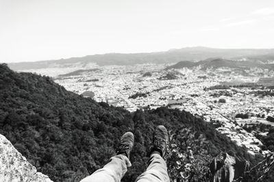 Low section of person on mountain against sky