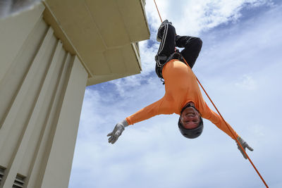 Man rappelling down a building.