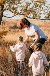 Outdoor sports activities. twin girls with tennis rackets go to mom