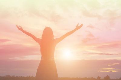 Silhouette woman standing against sky during sunset