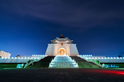 Low angle view of fountain building against sky at night