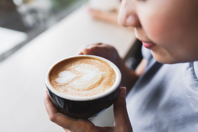 Midsection of woman holding coffee cup