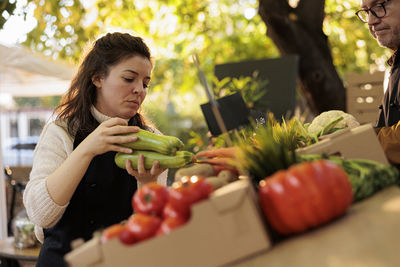 Portrait of smiling young woman eating food on table