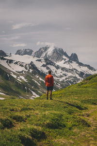 Young male stands looking at the mont blanc massif, chamonix, france.