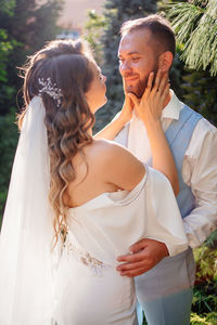 Couple holding hands with arms outstretched standing outdoors