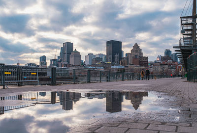 Reflection of buildings in city against sky