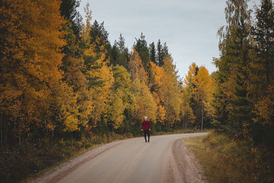 Man aged 23 wearing a checked red and black shirt walks along a foamy path. kainuu region, finland.