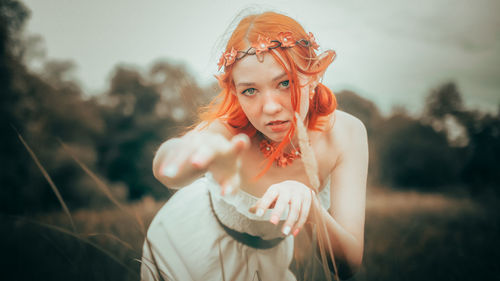 Portrait of young woman standing against sky