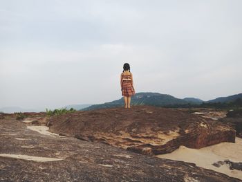 Rear view of woman standing on mountain