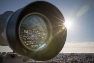 Cityscape seen through hand-held telescope against sky